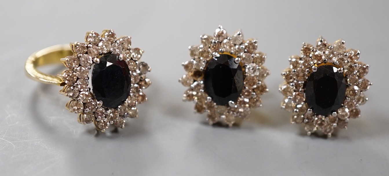 A modern suite of yellow metal, sapphire and diamond cluster set jewellery, comprising a ring, size H and a pair of earrings, 15mm, gross weight 10.4 grams.